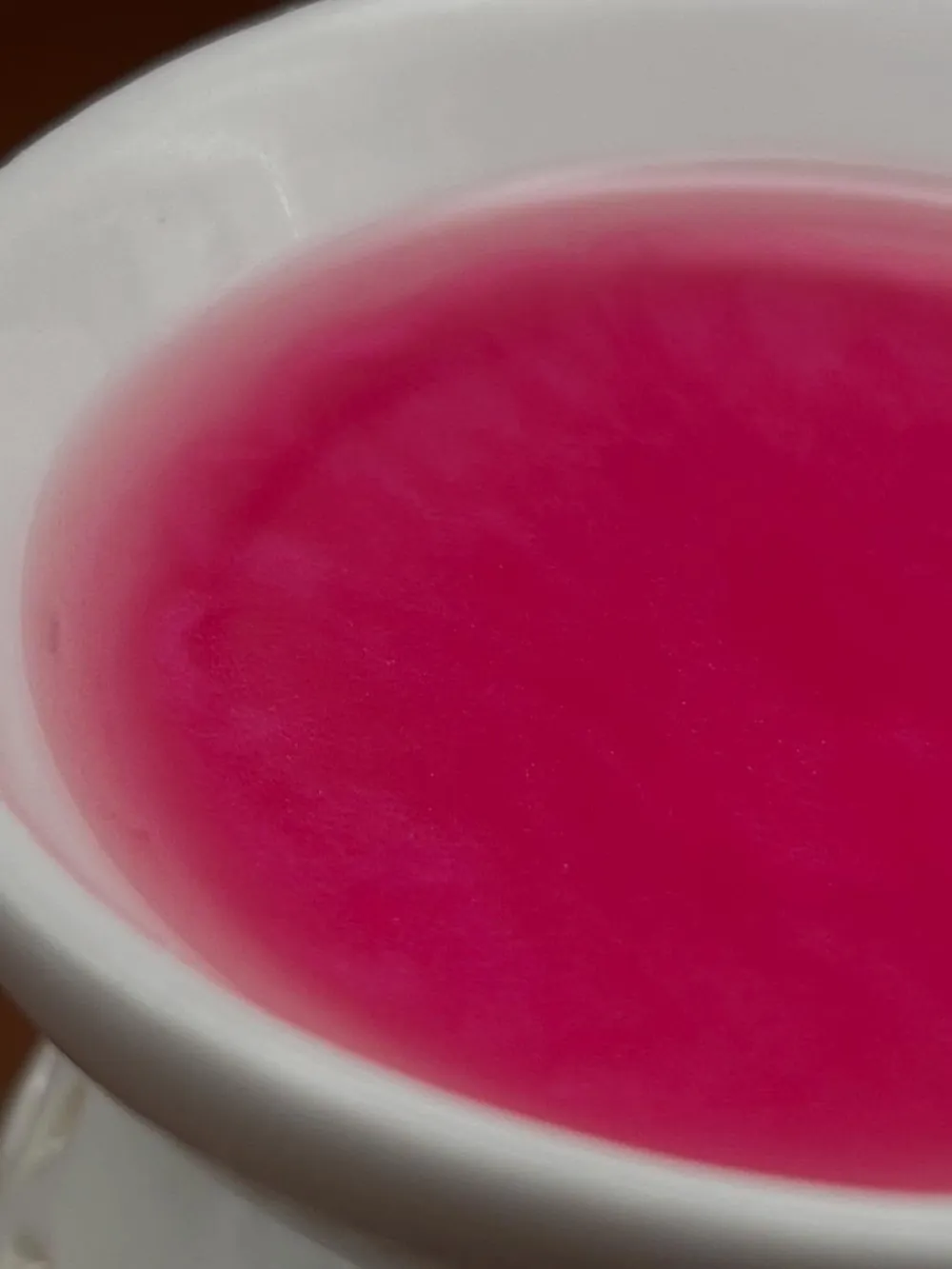 Wax melt rosa derretido en un quemador de cerámica blanca