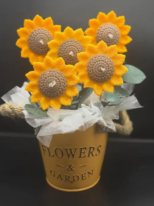 Bouquet de velas girasol tejidas en crochet en una cubeta dorada